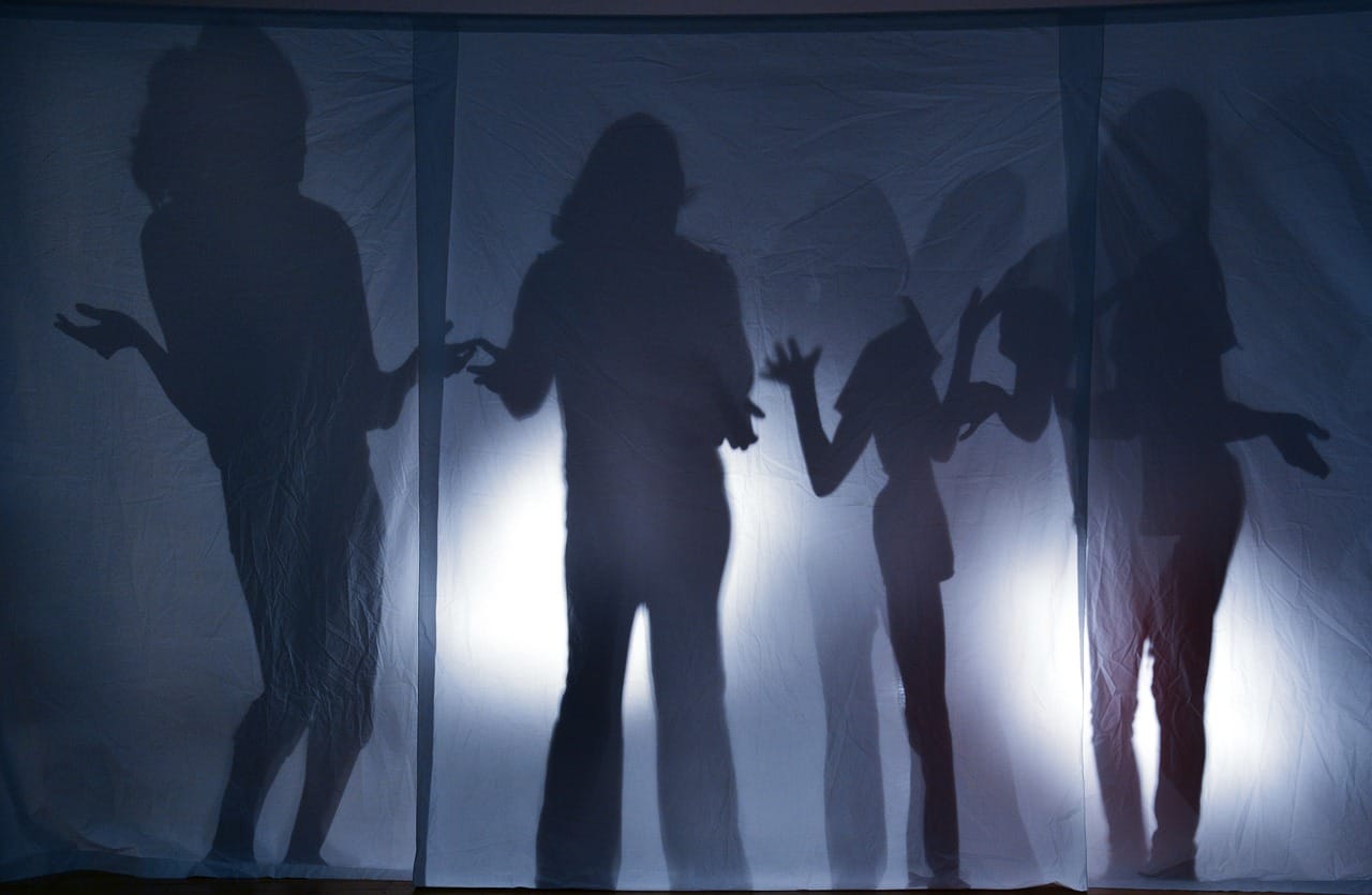 Sombras de personas en una tela blanca.