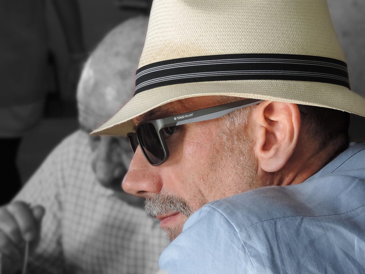Hombre con sombrero y gafas de sol mirando hacia un lado
