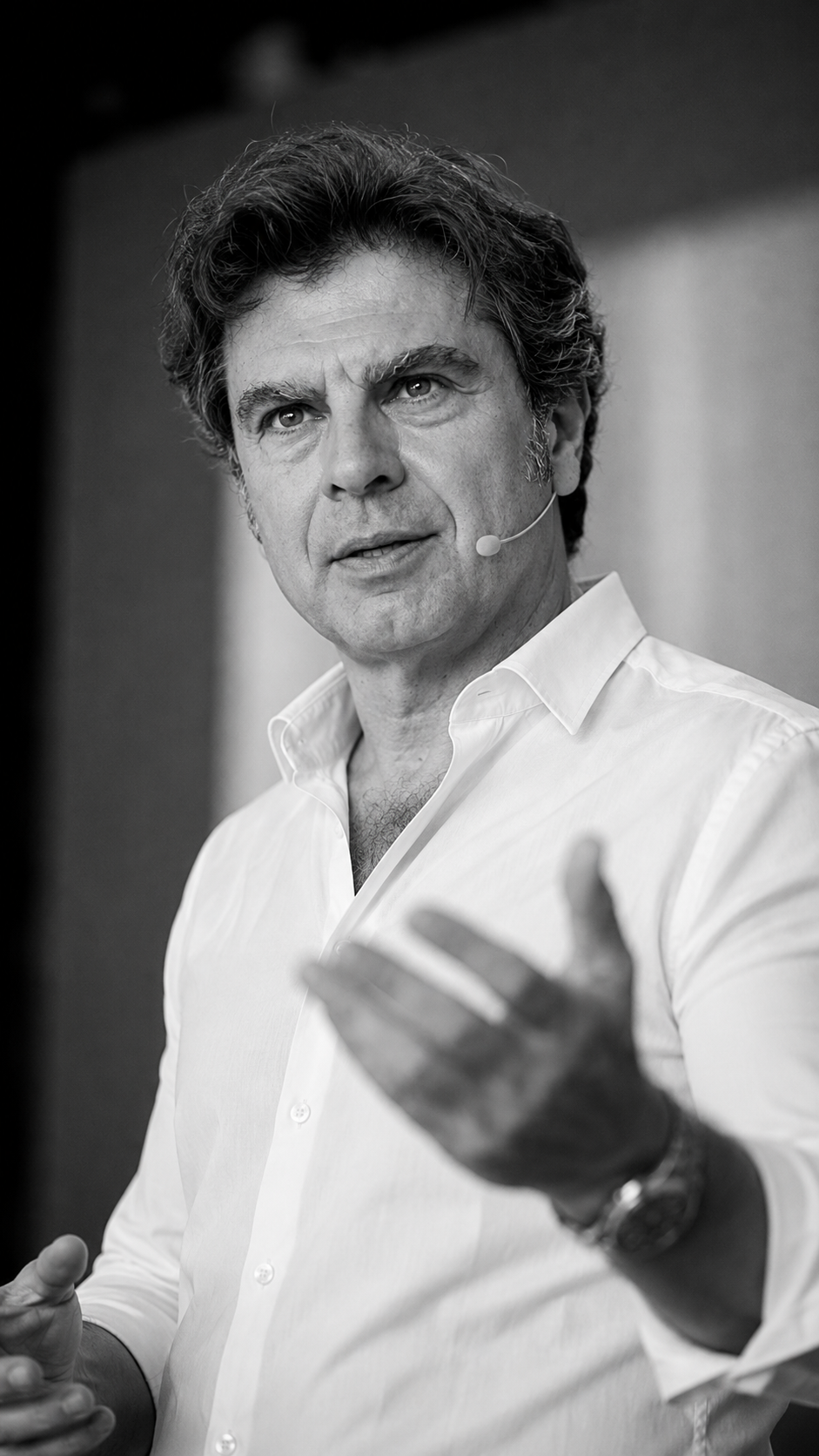 Hombre con micrófono de solapa gesticulando durante una presentación.. Curso coaching en asturias
